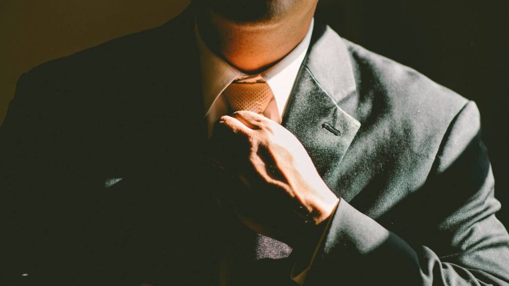 A photo of a businessman rearranging his tie