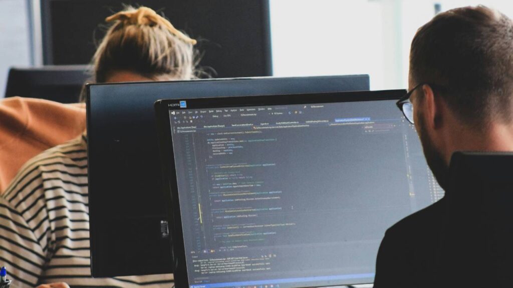 A woman and a man using computers