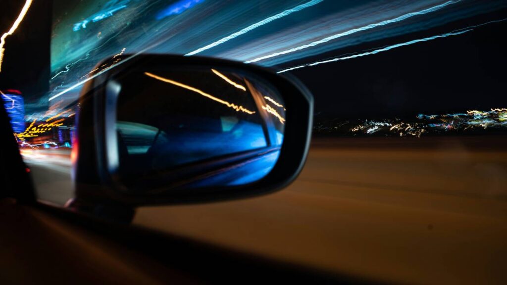 A rear-view mirror of a moving automobile