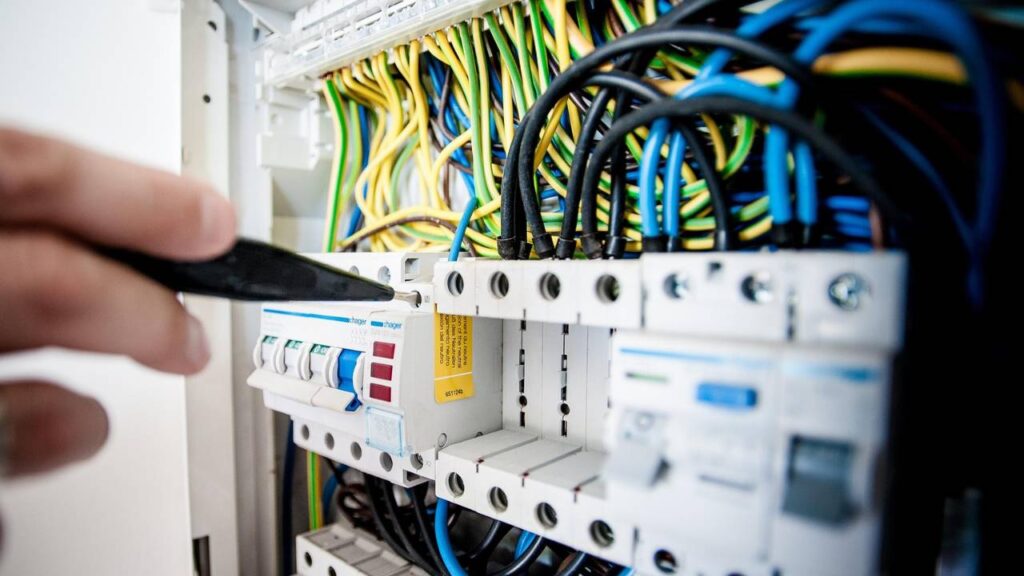 A close-up photo of a person inspecting the electrical components 