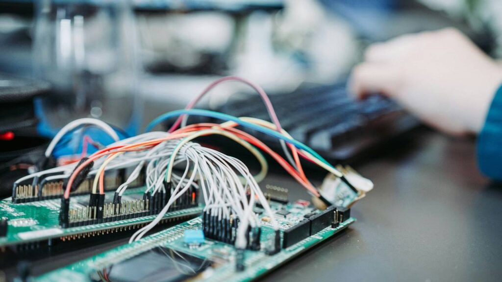 Two boards connected by multiple wires on a computer desk 